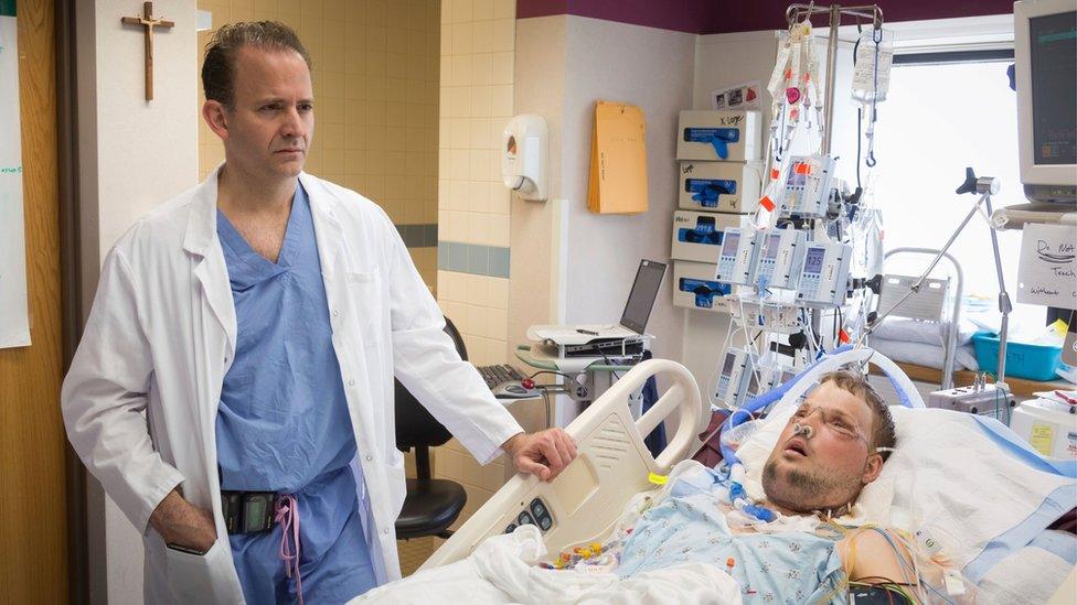 Dr Mardini stands next to Andy's hospital bed as he recovers from surgery