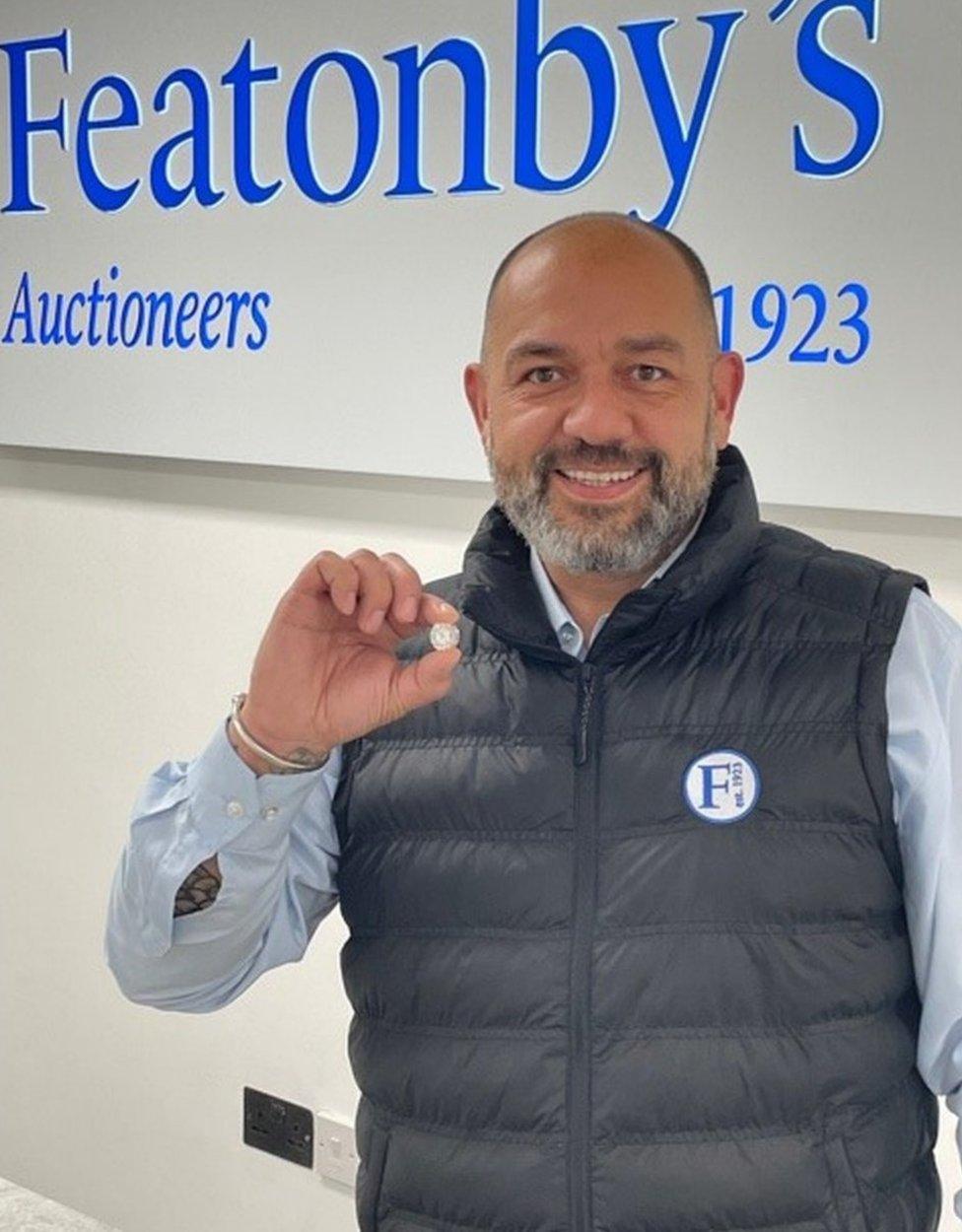 Auctioneer Mark Lane holding the diamond