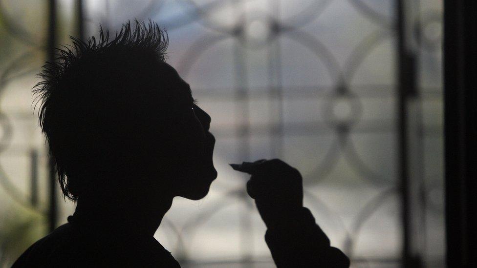 An undentified Indian youth takes Buprenorphine under an Oral Substitution Therapy (OST) programme at the office of The Manipur Network of Positive People in Imphal