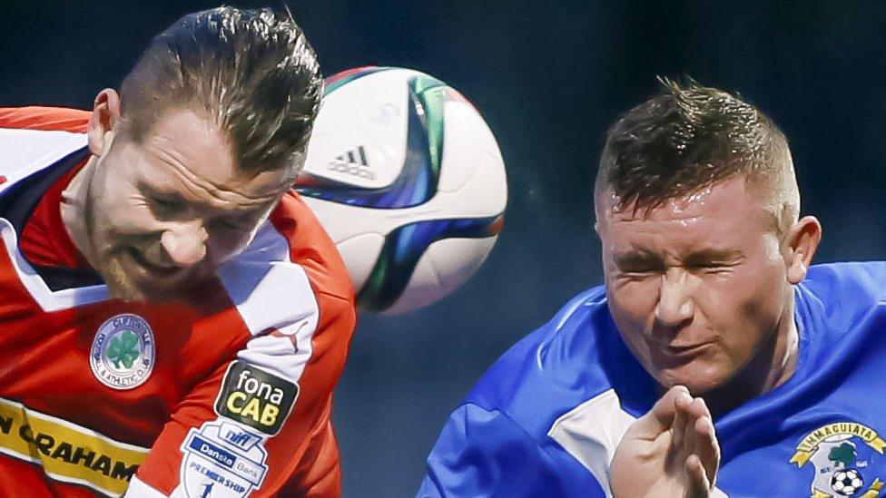 Marc Smyth of Cliftonville and Immaculata's Daniel Largy contest a high ball at Solitude