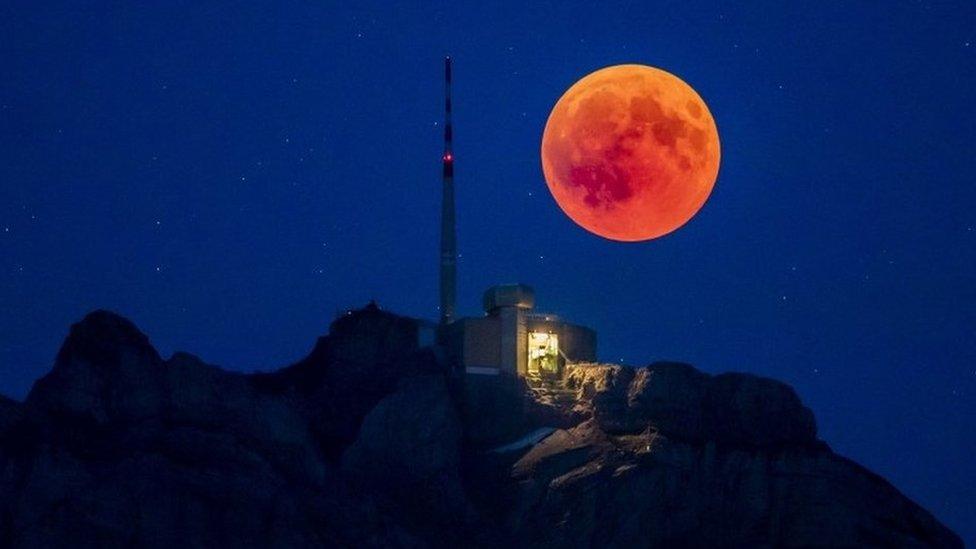 The blood moon rises behind the Saentis (2502m) Alpstein, Canton of Appenzell, Switzerland.