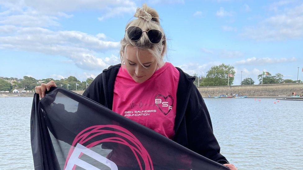 Chrissy holding a Ben Saunders foundation flag before taking part in her channel swim.