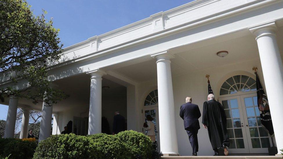 President Donald Trump (L) walks with Supreme Court Justice Neil Gorsuch at the White House.