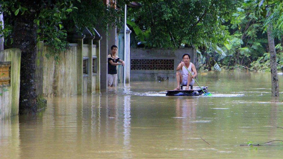 A man sits on a makeshift raft in a flooded area in Ha Tinh province, Vietnam, on 15 October 2016