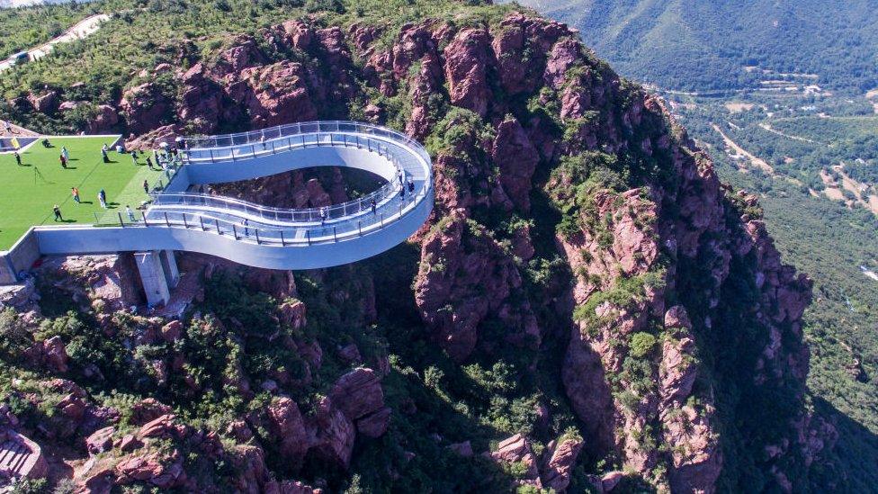 Aerial view of tourists walking on the glass skywalk at Fuxi Mountain tourism area on June 12, 2018 in Xinmi, Henan Province of China.