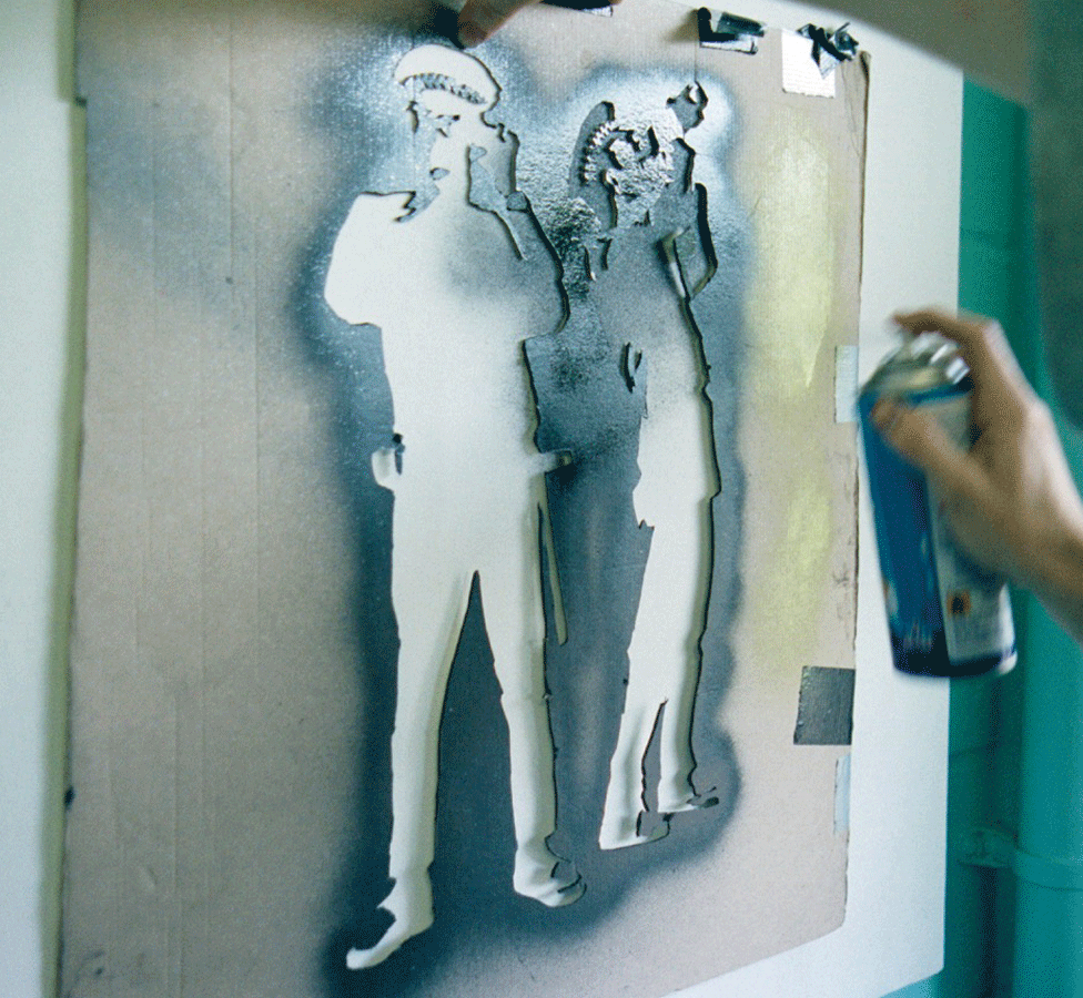 Banksy spraying a stencil