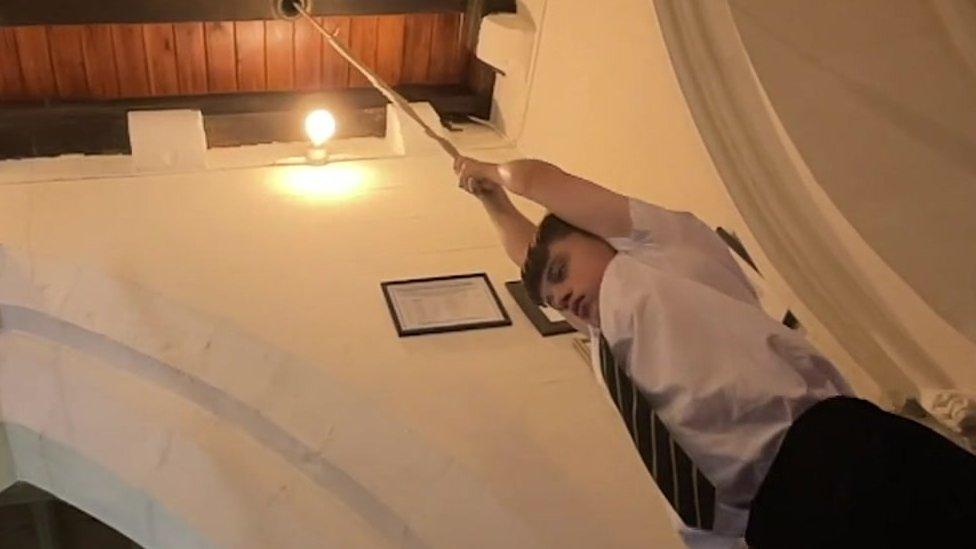 Boy pulling rope from a ceiling