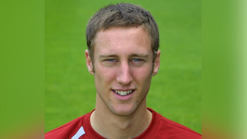 A headshot of Chris Roberts in football kit. He has short brown hair and blue eyes.