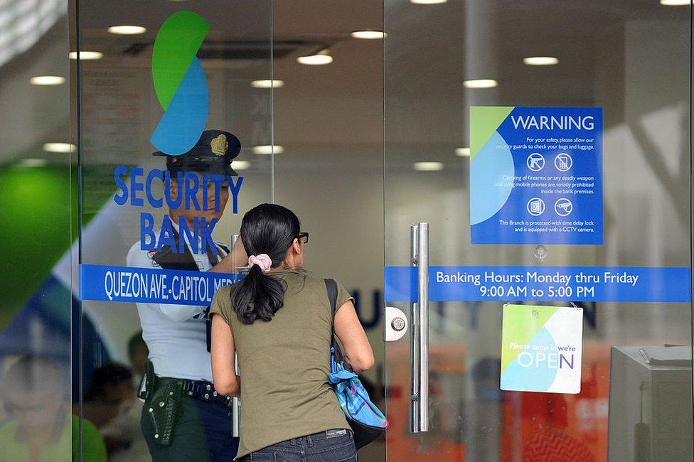 A customer enters a branch of the Security Bank in Manila on January 14, 2016