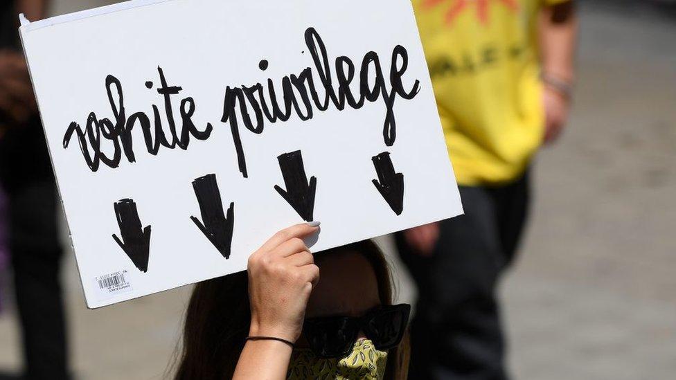 Placard with white privilege written