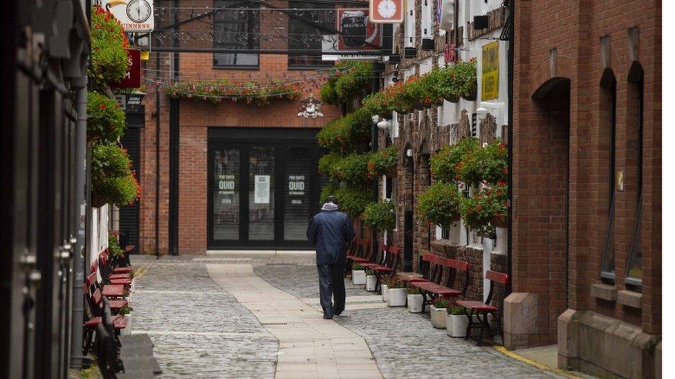 A man walks down Commercial Court in Belfast