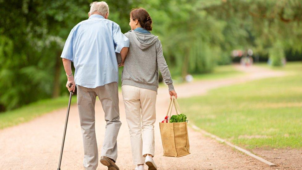 Caregiver gives assistance to an elderly man