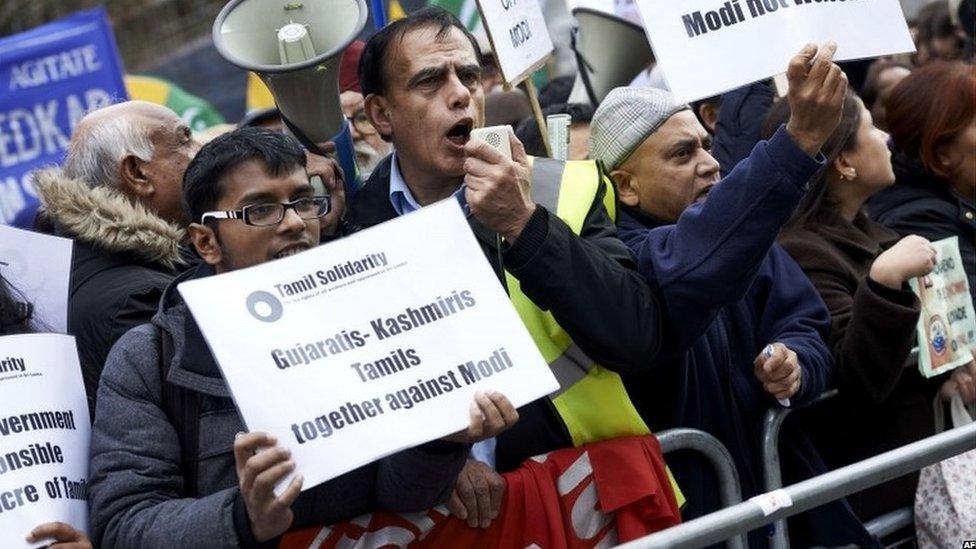 Protestors demonstrating against Indian Prime Minister Narendra Modi hold placards by Parliament square in central London on November 12, 2015.