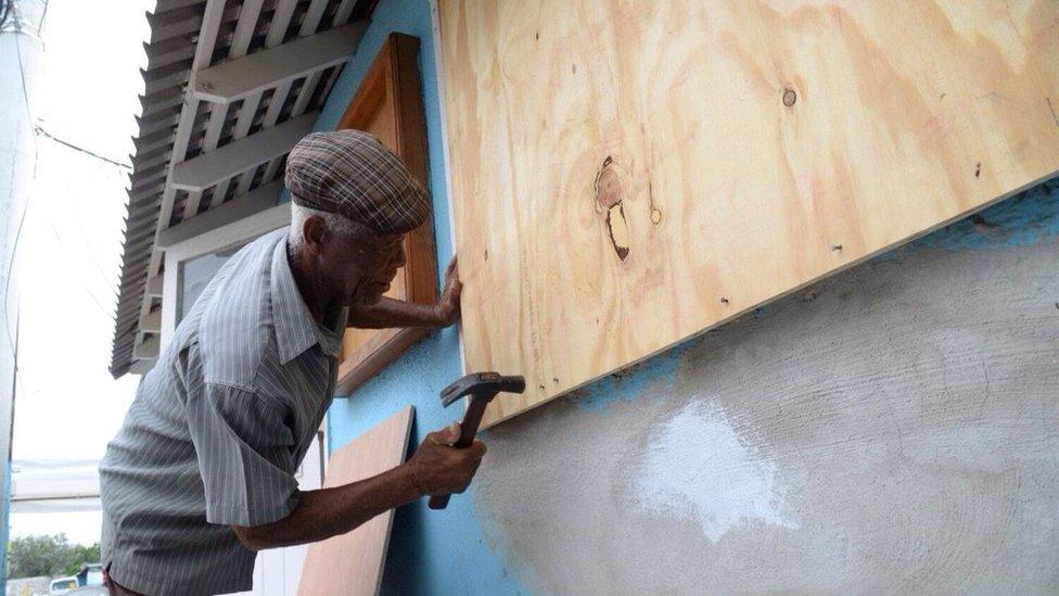 Man boarding up windows on a building