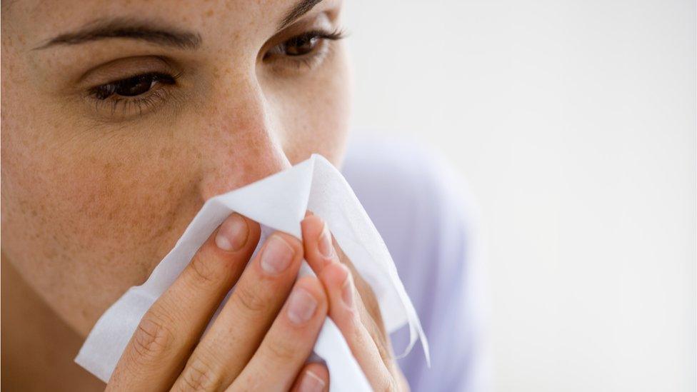 Woman blowing nose