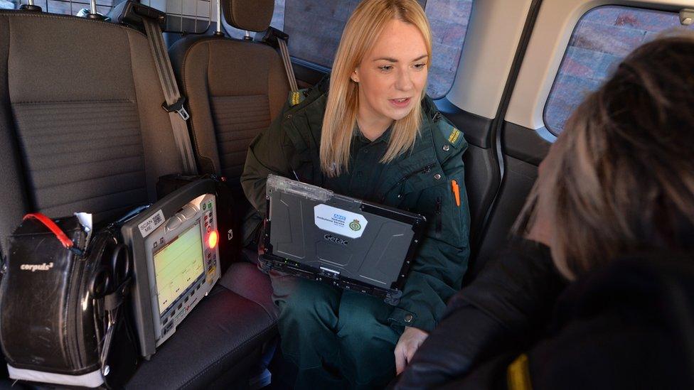 Paramedic speaking to patient in response vehicle