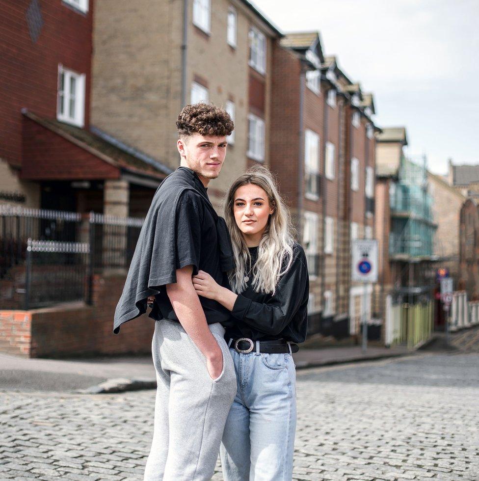 Portrait of a young couple standing in a street