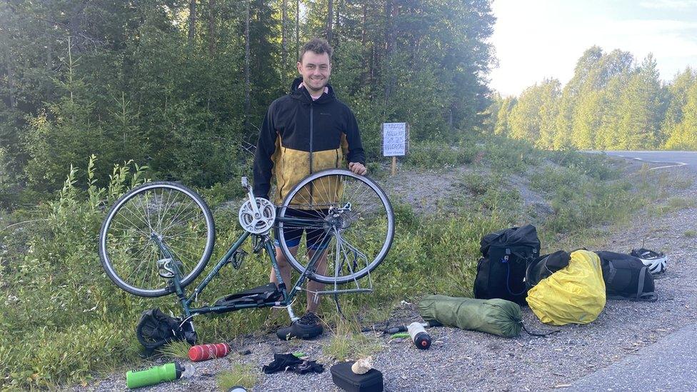 Man holds bike upside down after it breaks down