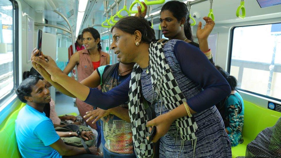 Transgender employees take selfies inside one of the new coaches of the Cochin metro