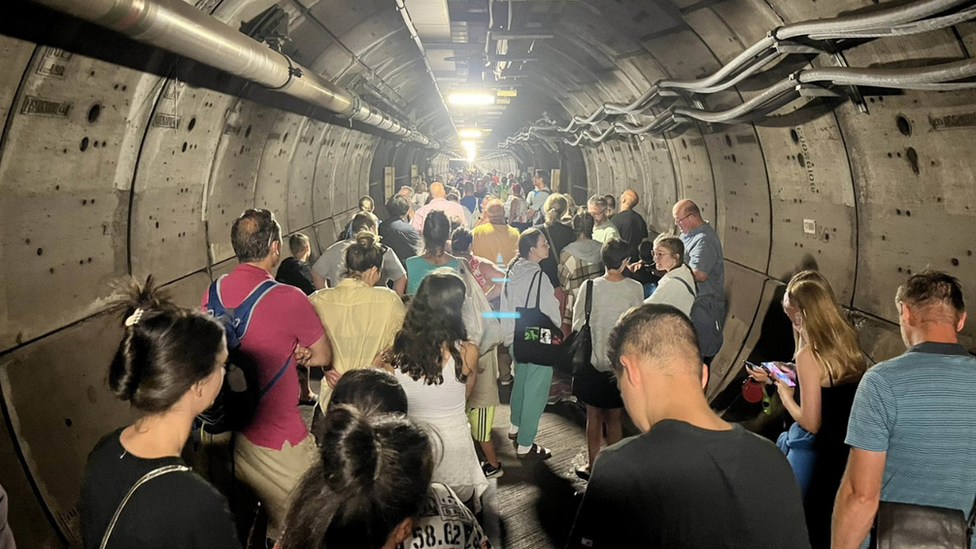 Passengers walk along an emergency tunnel of the Channel Tunnel