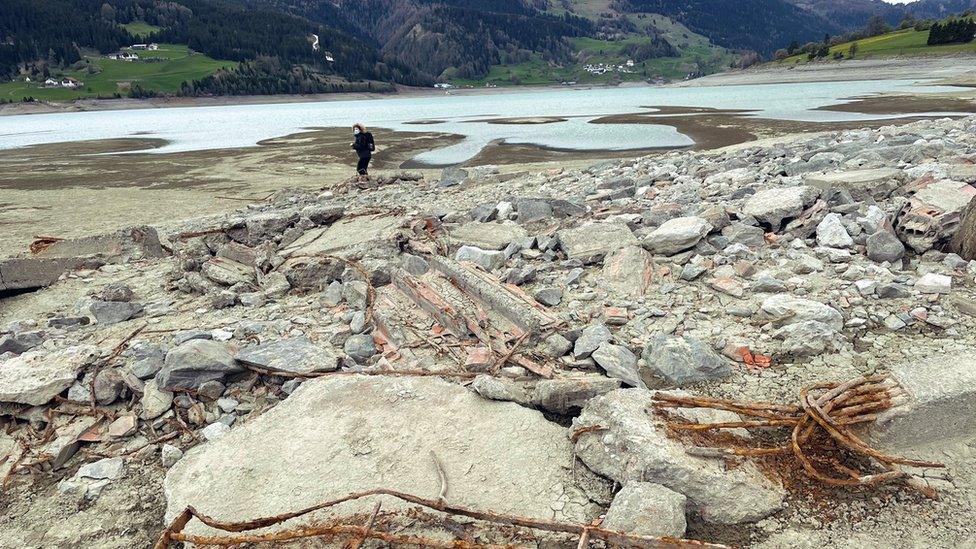 A person stands in the rubble at Lake Resia