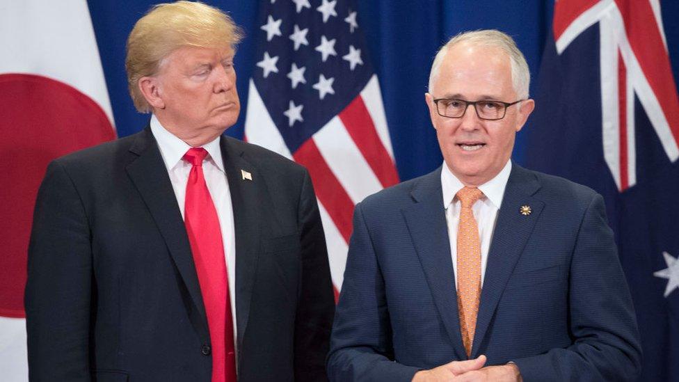 Donald Trump and Malcolm Turnbull stand in front their nations' flags during a meeting in 2017