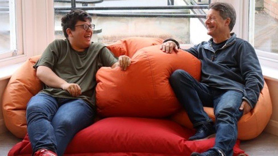 A mentor sitting in a bean bag with a young person