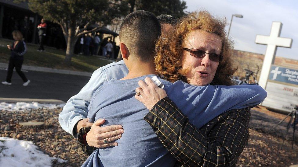 A parent embraces her child after a shooting at Arapahoe High School, Colorado