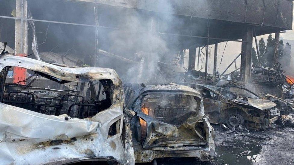 Destroyed vehicles are seen at the site of a Russian military strike