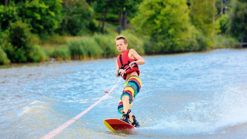 child wakeboarding on the water