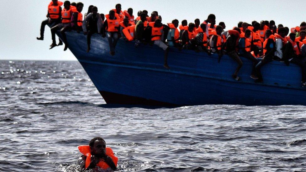 Migrants wait to be rescued as they drift in the Mediterranean Sea off the coast of Libya on 3 October