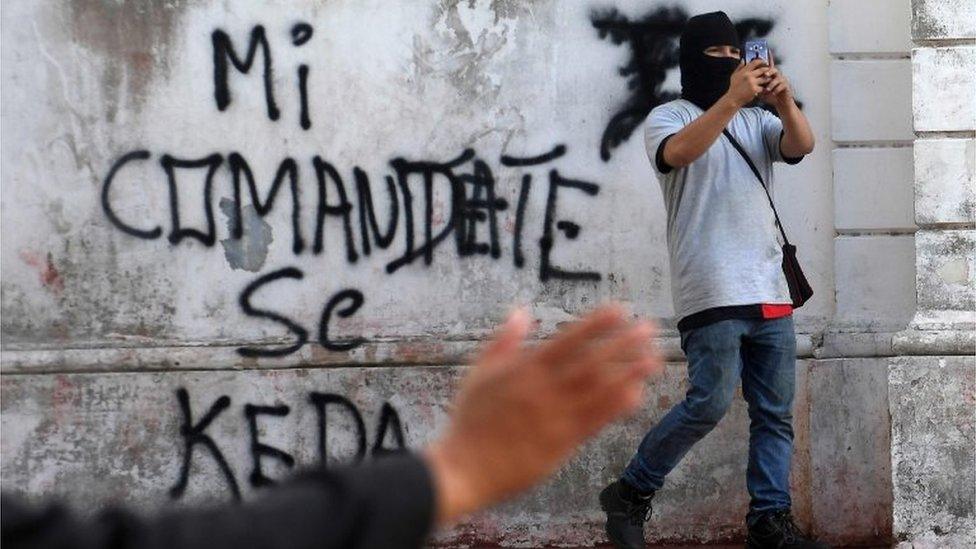 A supporter of under-pressure Nicaraguan President Daniel Ortega films outside the San Sebastian Basilica in Diriamba, Nicaragua, on July 9, 2018