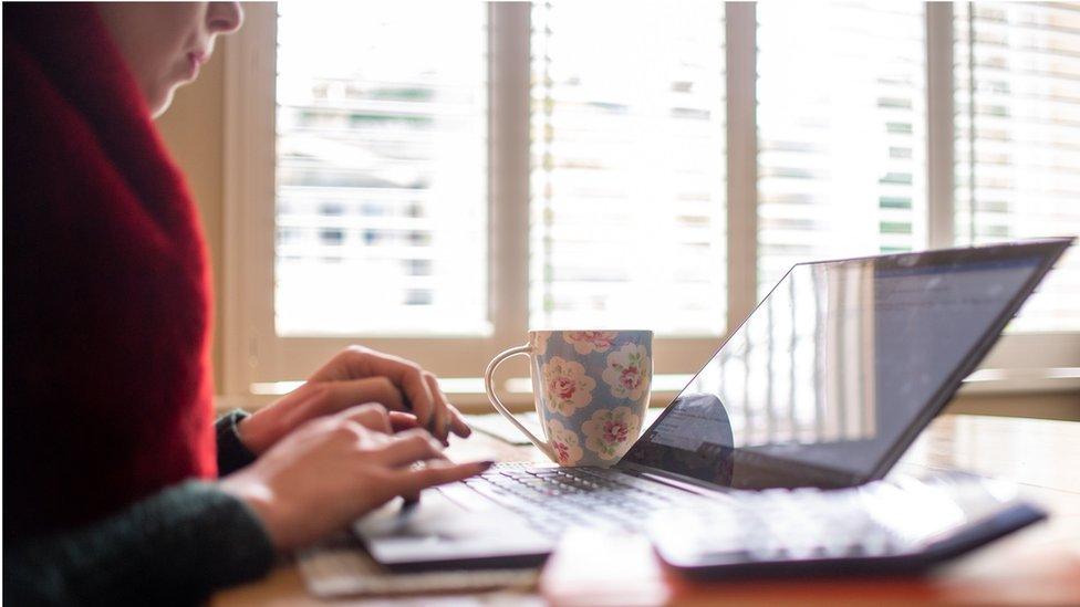 A woman works from home on a laptop