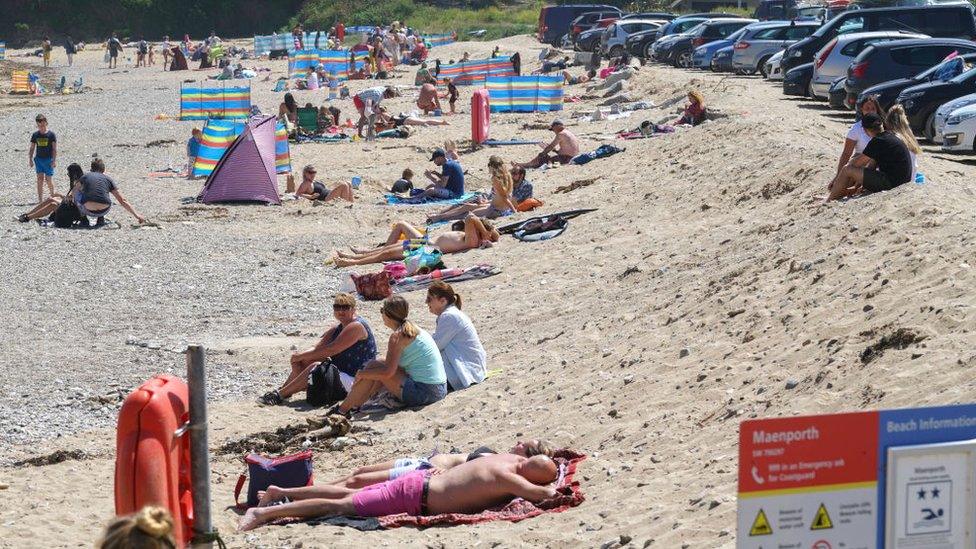 People relaxing and enjoying the sun at Maenporth Beach on May 30 in Cornwall