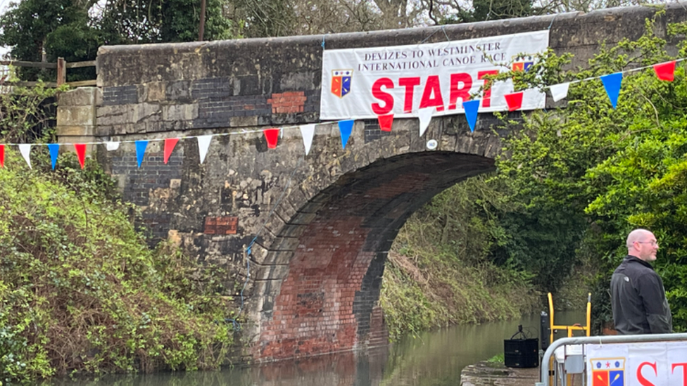 Bunting and a banner hanging from a bridge mark the start line