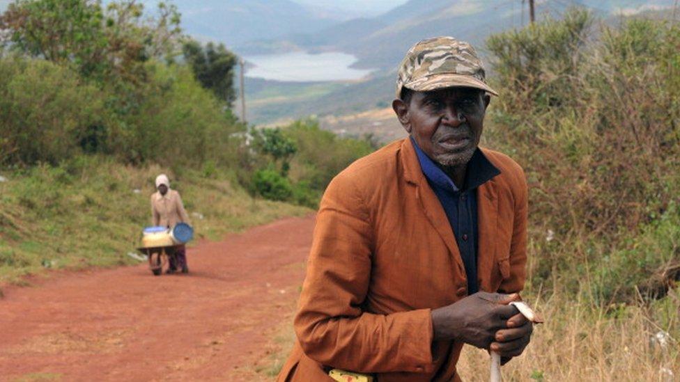 A member of the Venda tribe poses on October 6, 2011 in Tshiavha in front of South Africa's Lake Fundudzi among the foothills of the Soutpansberg mountains, in the northern province of Limpopo