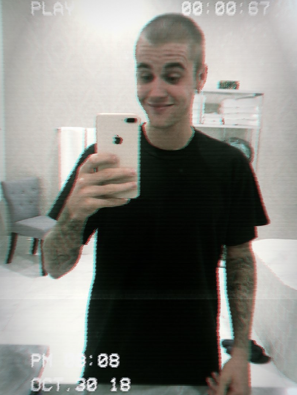 Justin Bieber taking a selfie after shaving his hair off