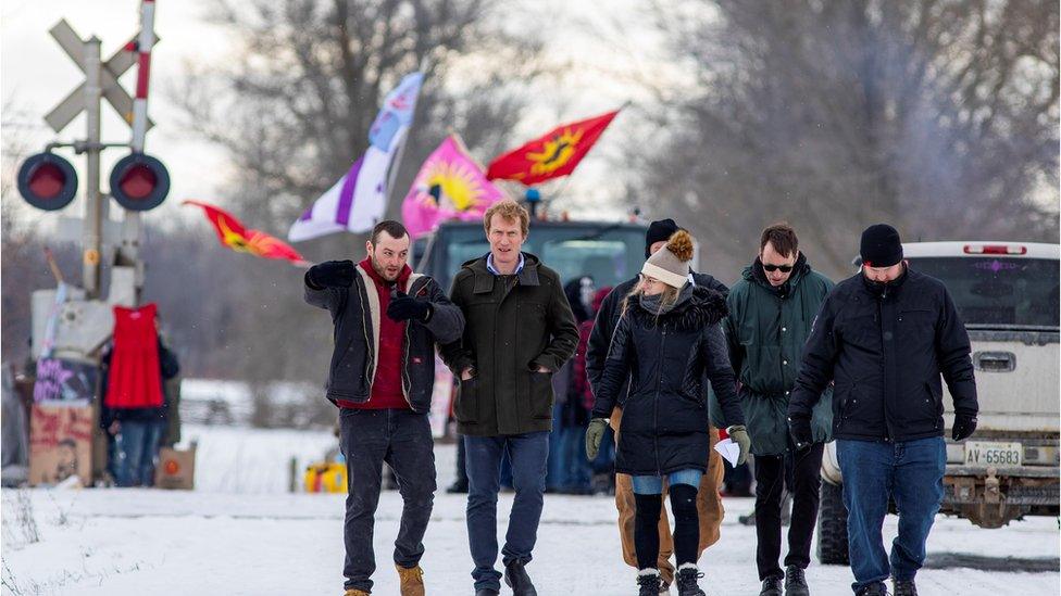 Indigenous Services Minister Marc Miller walks with representatives of the Mohawk Nation