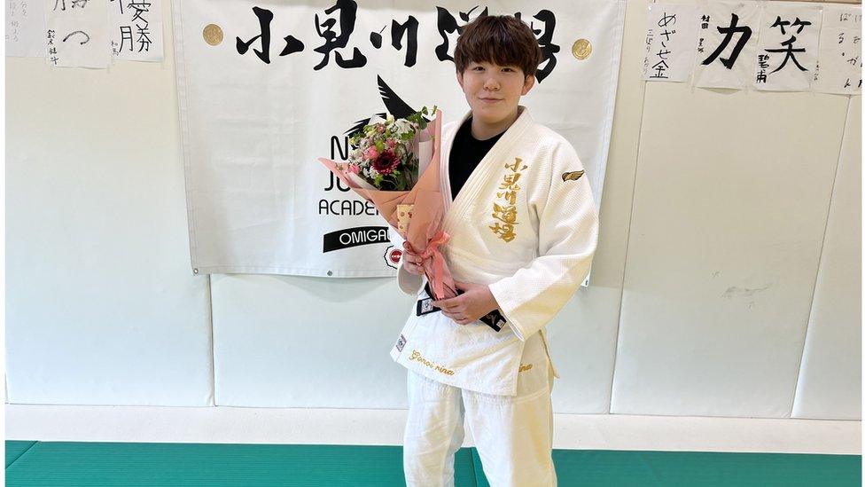 Rina Gonoi holding bunch of flowers in Judo uniform