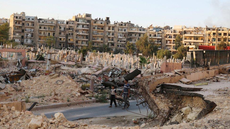 People walk near an over-crowded graveyard in the rebel held al-Shaar neighbourhood of Aleppo, Syria on 6 October 2016