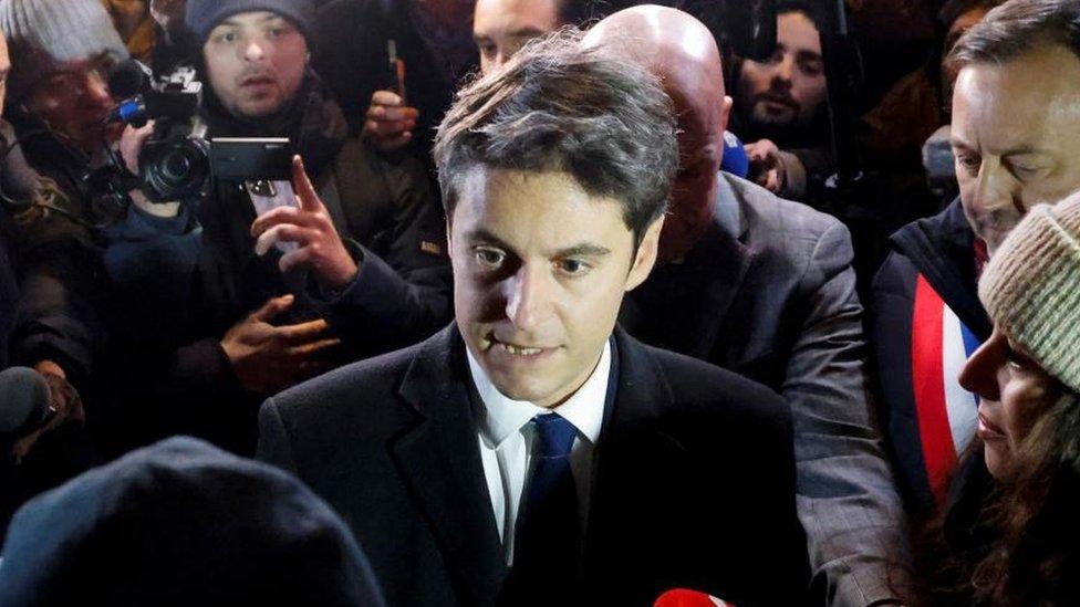 Gabriel Attal speaks to local residents affected by floods, outside a cafe and tobacconist in Clairmarais, northern France on 9 January 2024.