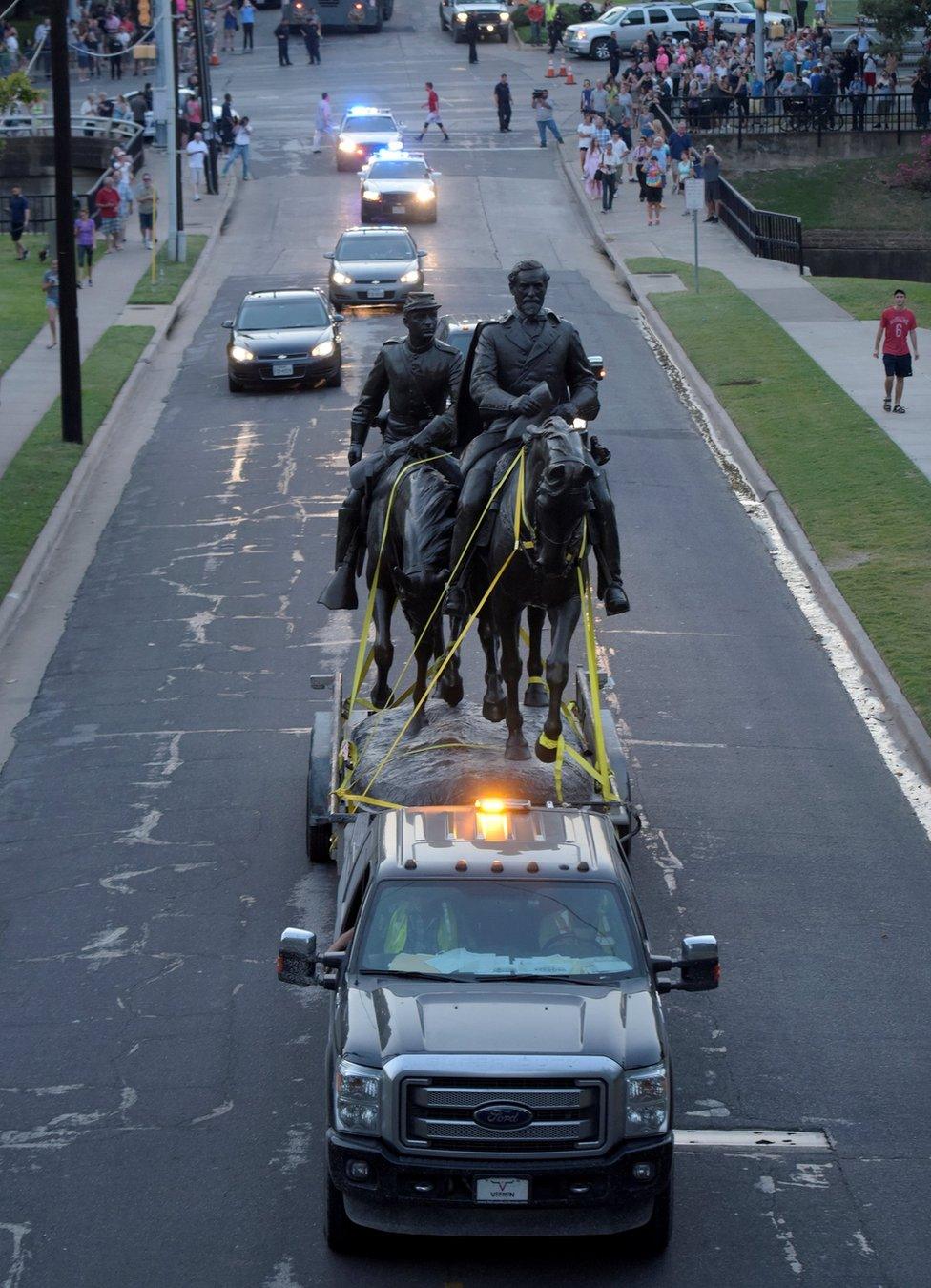 The statue of Confederate general Robert E. Lee is escorted after removal from its platform in Dallas, Texas, U.S., September 14, 2017