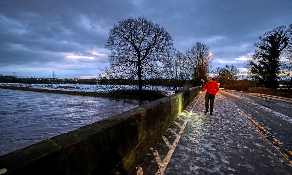 A council worker in Didsbury, Manchester, checks a bridge for damage after heavy rainfall, on 21 January 2021