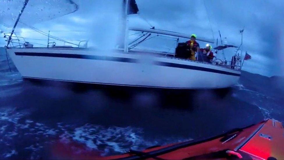 Photo of yacht in stormy seas with crew on board