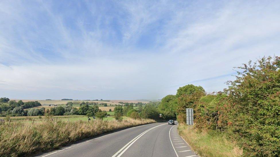 A rural road with grass either side