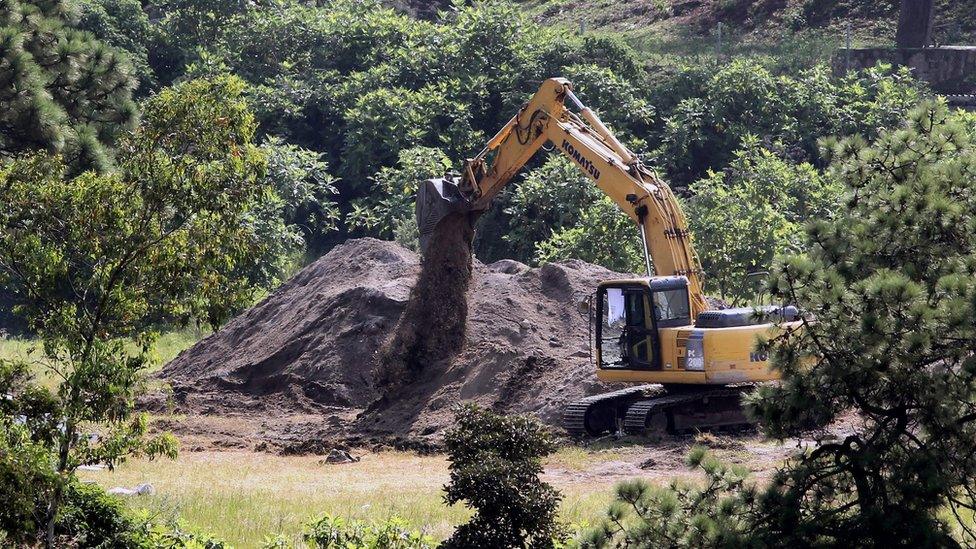 A digger uncovering the mass grave in Jalisco, Mexico, earlier in September