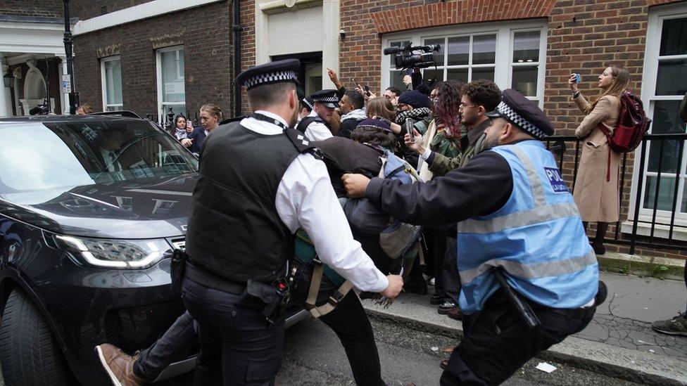 Police officers remove a protester trying to block Sir Keir's car following the speech