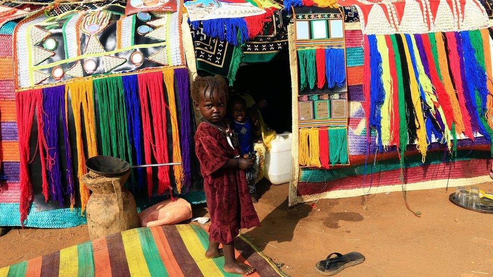 A child stands in front of a decorated house during the Sudanese president's visit to the war-torn Darfur region at Rapid Support Forces Headquarter in Umm Al-Qura, Darfur, Sudan (September 23, 2017)