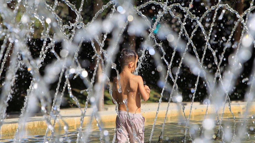 A boy takes a bath in a fountain in Madrid Rio park, in Madrid, Spain, 01 August 2018.