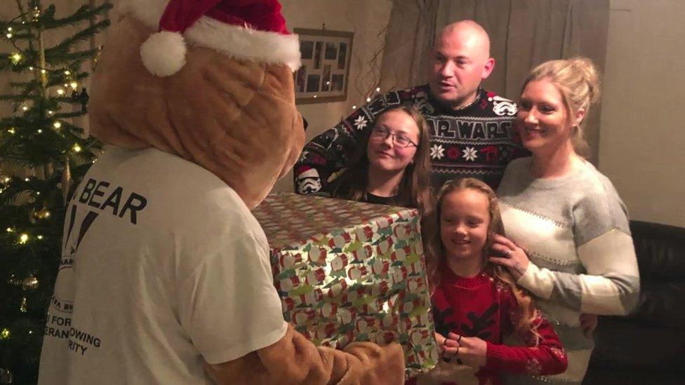 Family receiving hamper from Dave Viner in bear costume